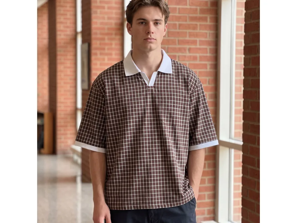 A man wearing a brown plaid short-sleeve polo shirt with a white collar.