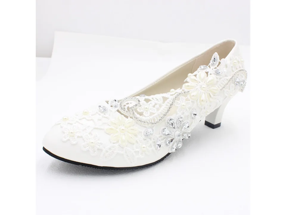 A single white lace bridal pump with floral and rhinestone details.