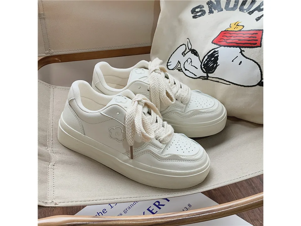 A pair of white casual low-top sneakers shown from the side.