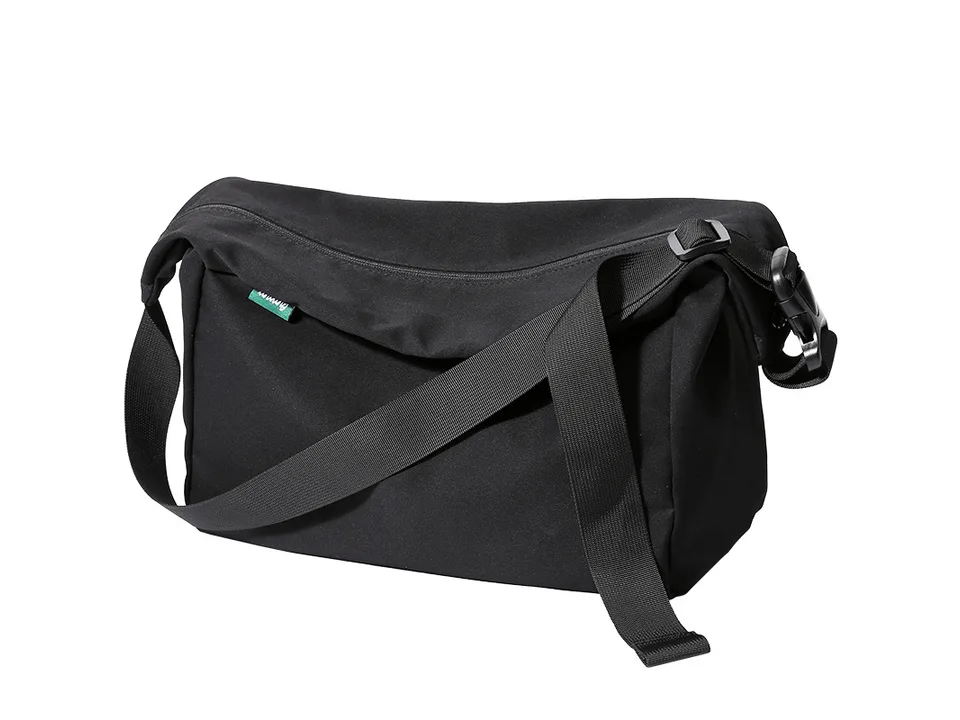 A black casual messenger bag made of Oxford fabric.