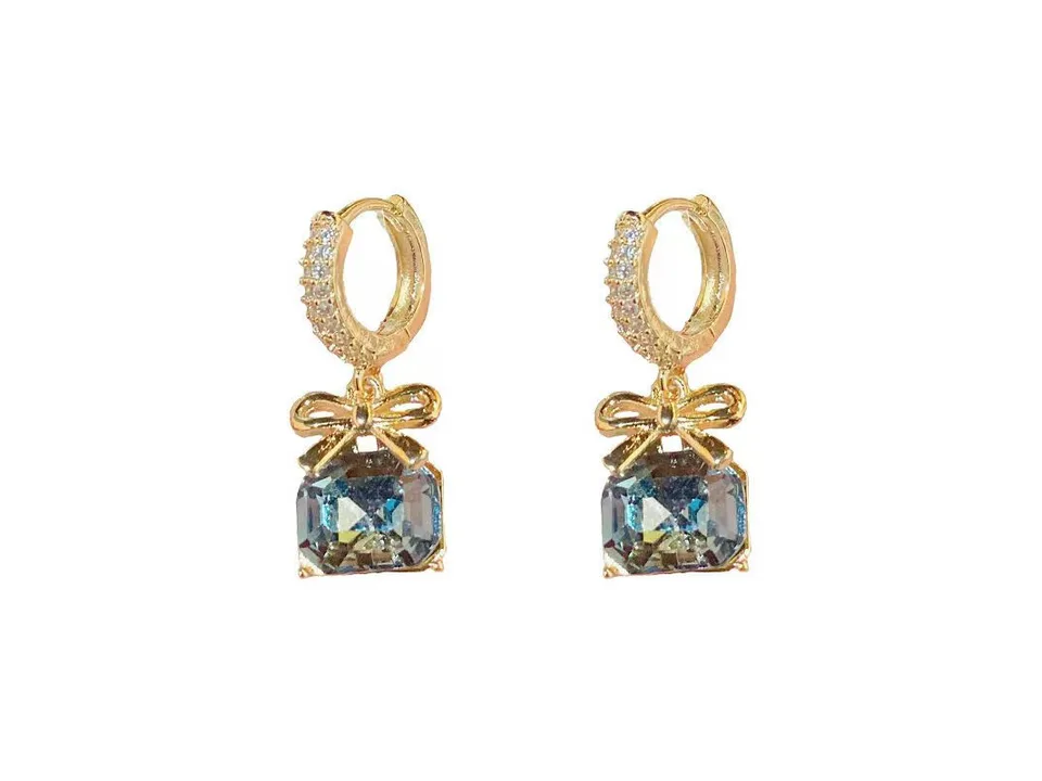 Gold hoop earrings with a bow and a blue crystal drop.