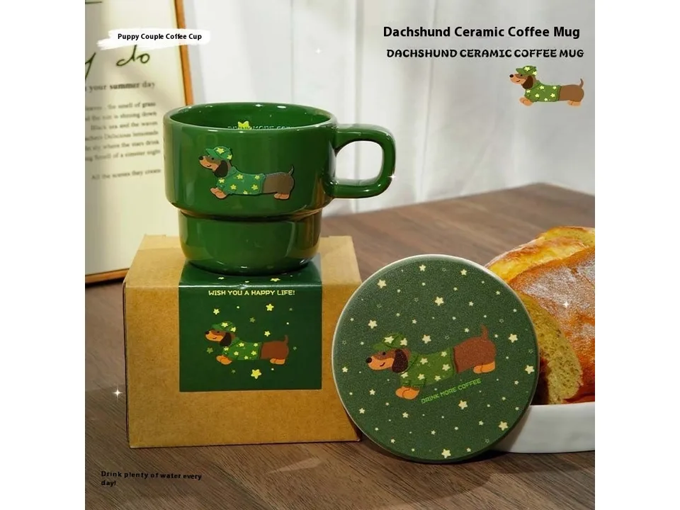 Green ceramic coffee mug with a dachshund design and matching coaster next to its packaging box.