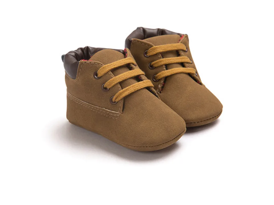 A pair of brown baby high-top shoes with yellow laces.
