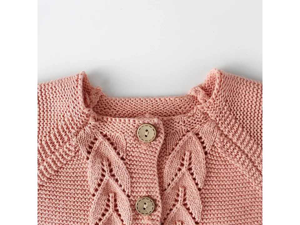 Close-up of the neckline and leaf-pattern knit detail on the cardigan.