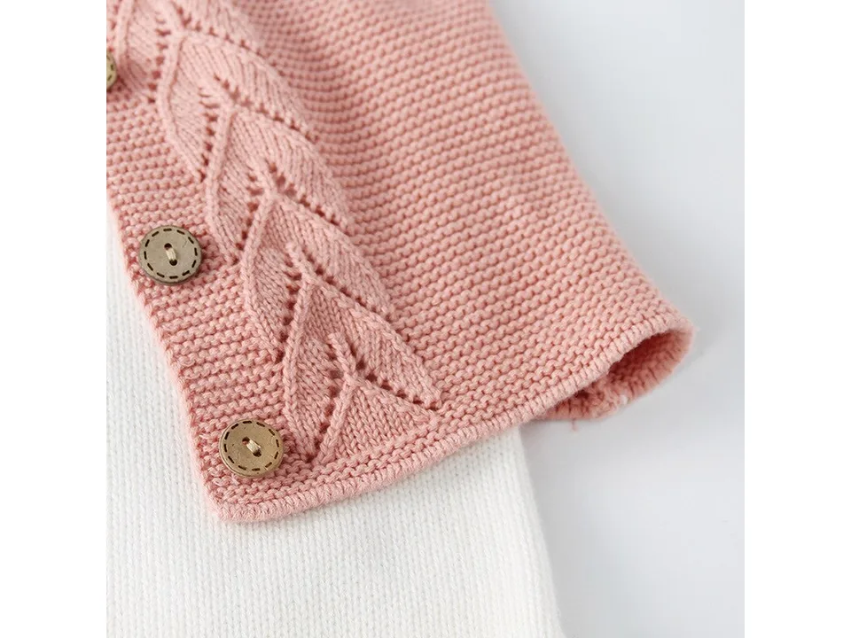 Pink knitted cardigan layered over a white romper.