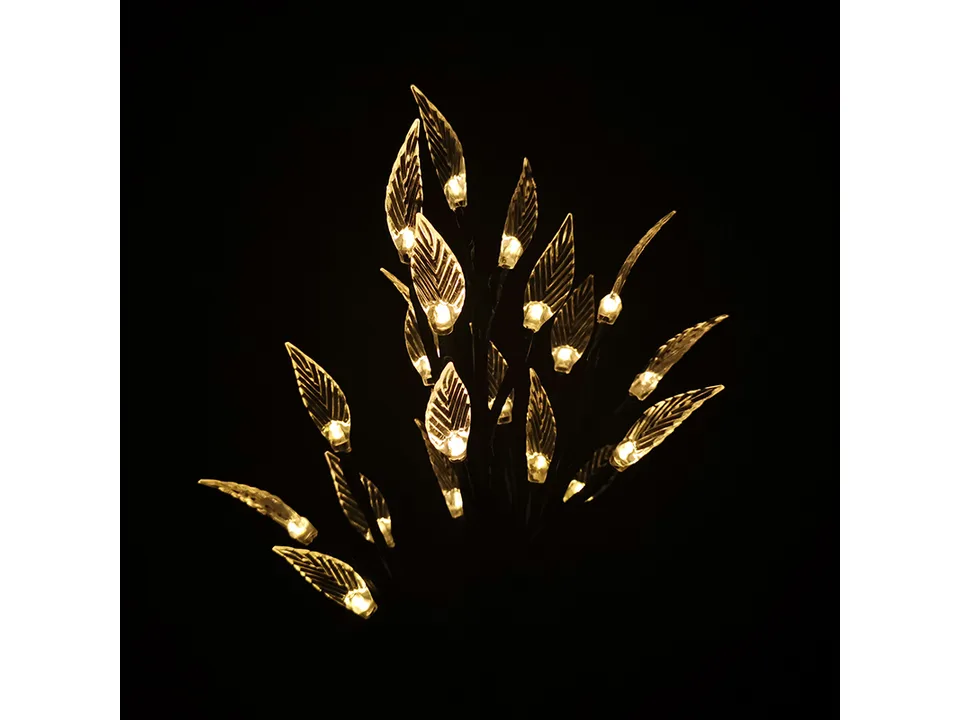 Solar LED leaf branch light glowing with warm light in the dark.
