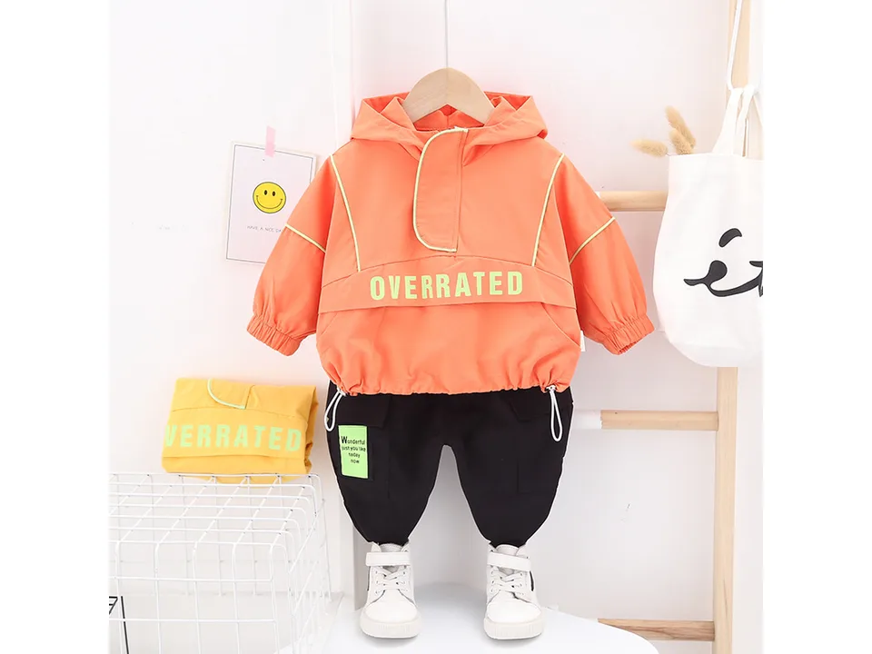 Orange hooded jacket and black pants set with an extra yellow jacket.