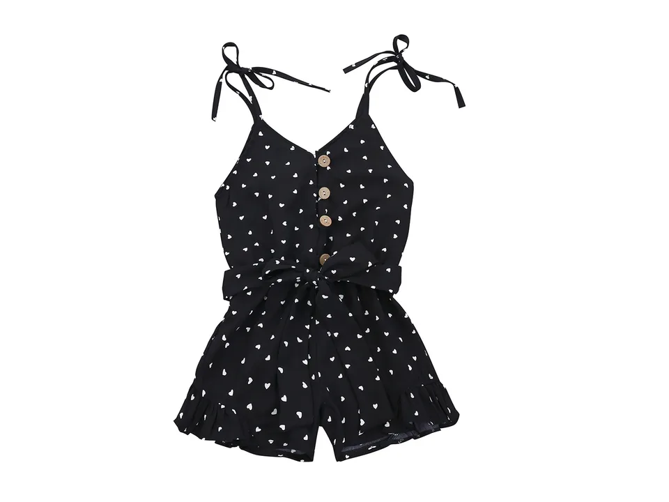 Front view of the black heart-print jumpsuit with button-down bodice and tie waist.