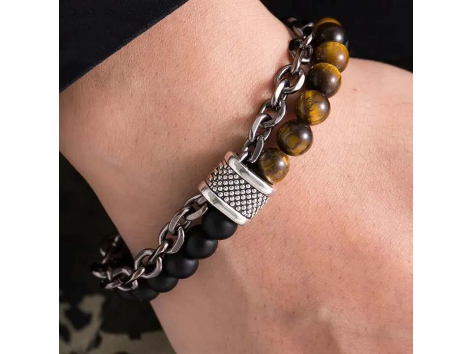 A close-up of a beaded and chain link bracelet being worn on a wrist.