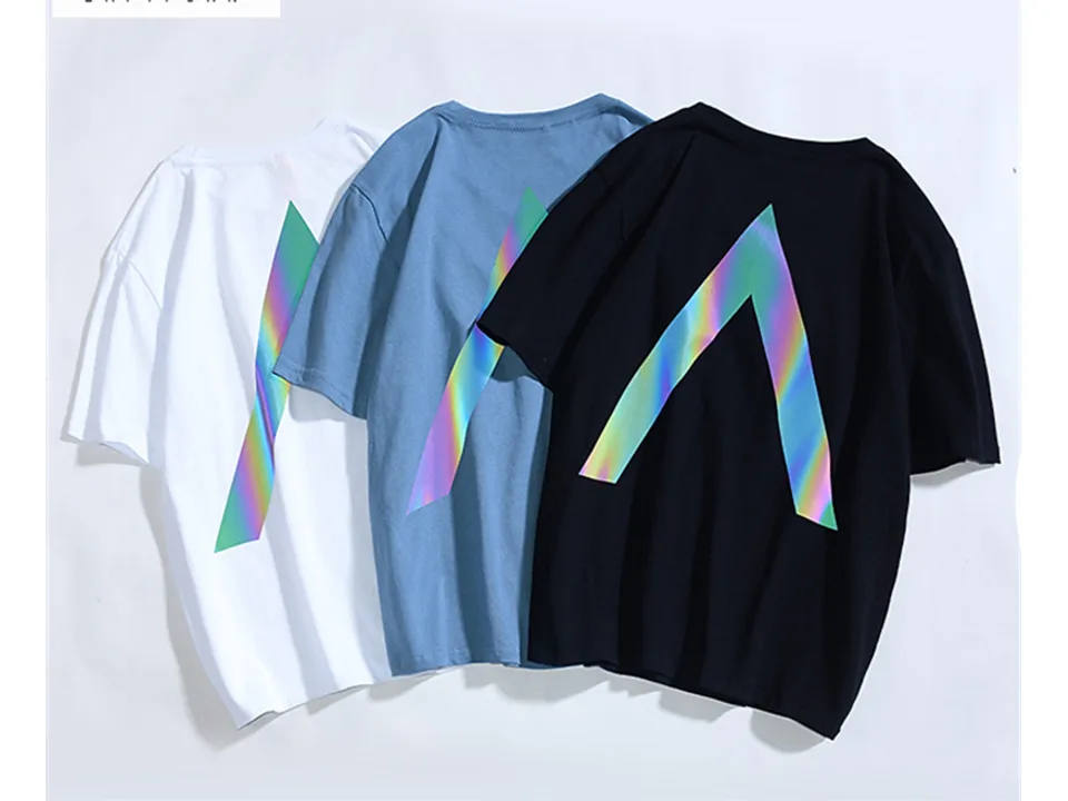 Three t-shirts in white, blue, and black, all featuring a reflective 'A' graphic on the back.