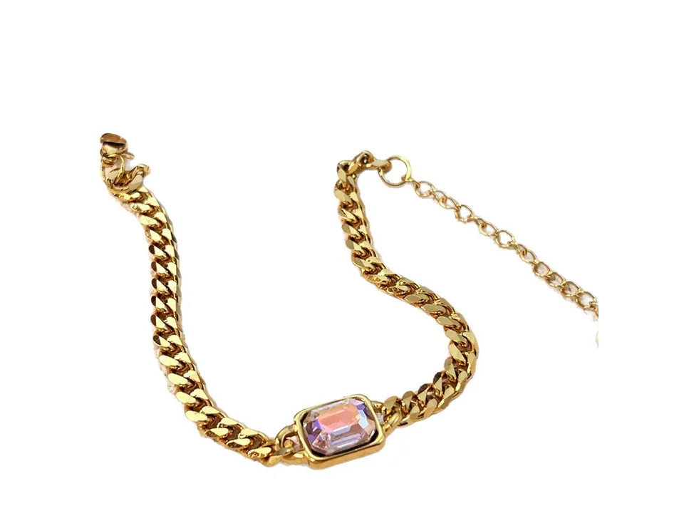 A single gold chain bracelet with a rectangular gemstone and an adjustable extension chain.
