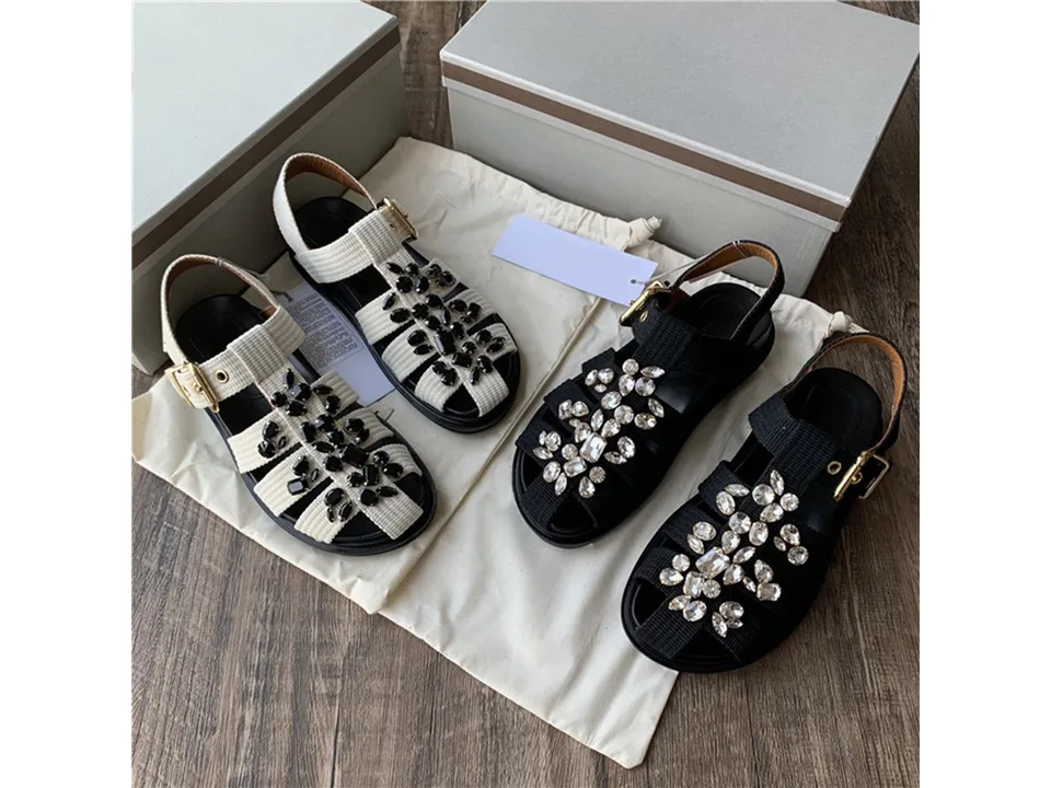 Two pairs of sandals, one black and one white, with rhinestone embellishments.