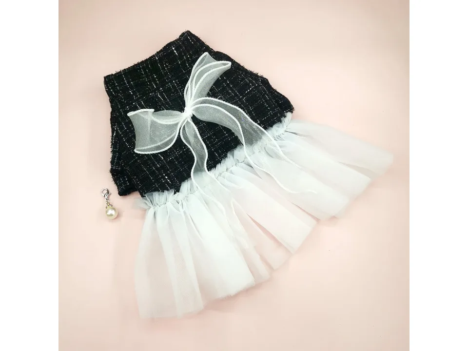 Black and white plaid dog dress with a white tulle skirt and a bow detail, viewed from an angle.