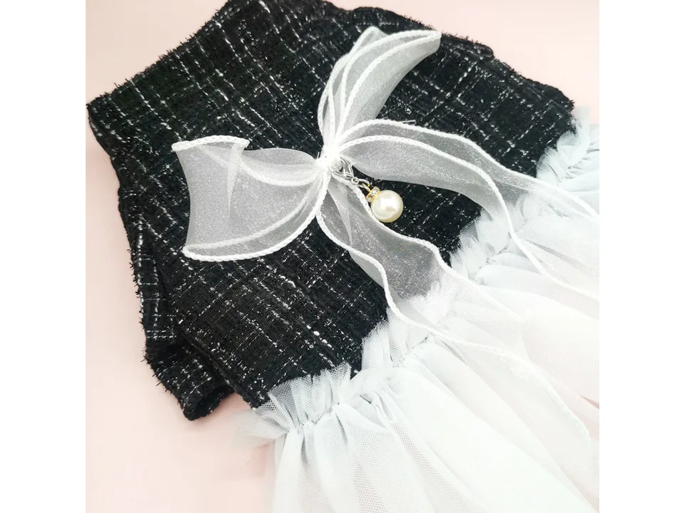 Close-up of the white organza bow and pearl charm on the black plaid dog dress.