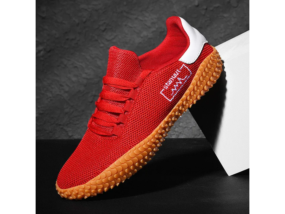 A single red low-top sneaker with an orange textured sole.