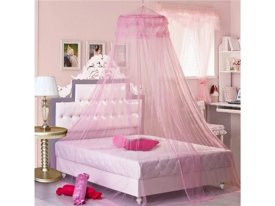 Pink hanging dome mosquito net over a bed.
