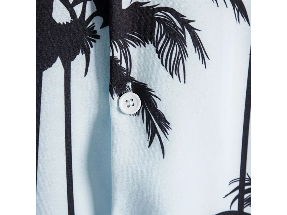 Close-up of a white button on the palm tree print shirt.