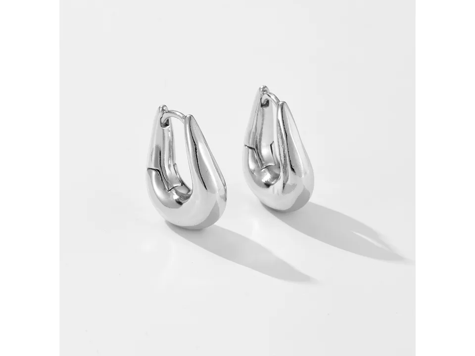 A pair of silver geometric hoop earrings on a white background.