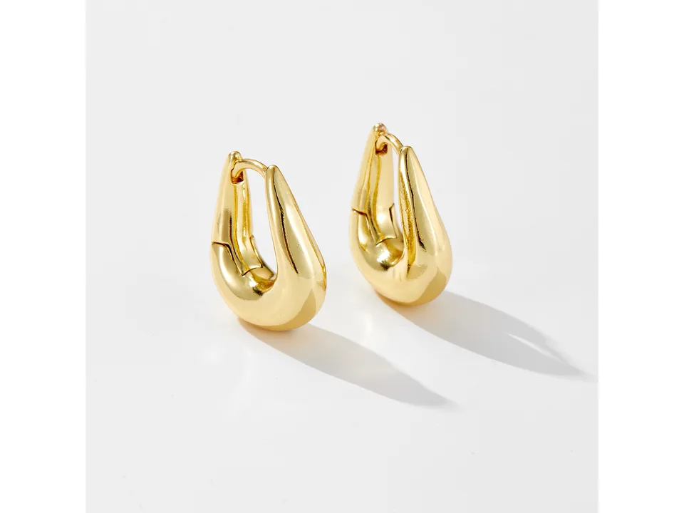 A pair of gold geometric hoop earrings on a white background.