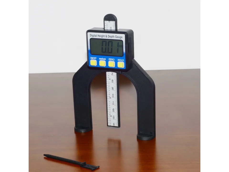 Digital height and depth gauge standing on a wooden surface.