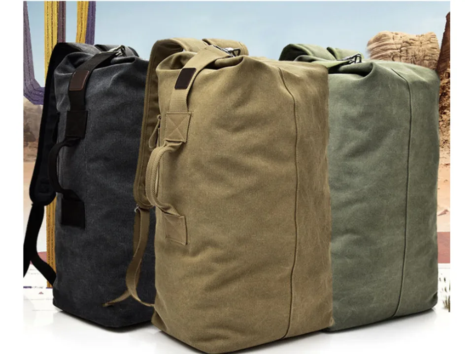 Three canvas backpacks in dark grey, khaki, and olive green standing side by side.