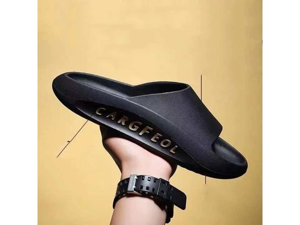 A black slide sandal with the word CARGFEOL on the side, held in a hand.