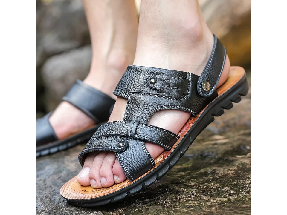 Black leather men's sandal worn on a foot