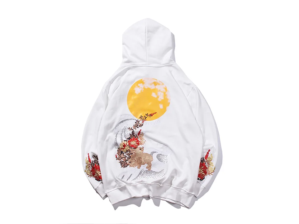 White hoodie with a large moon and rabbit embroidery on the back.