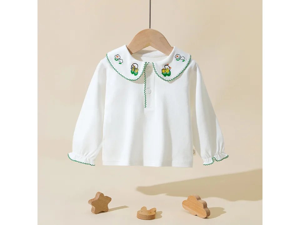 White long-sleeve shirt for girls with a green embroidered collar featuring flowers.