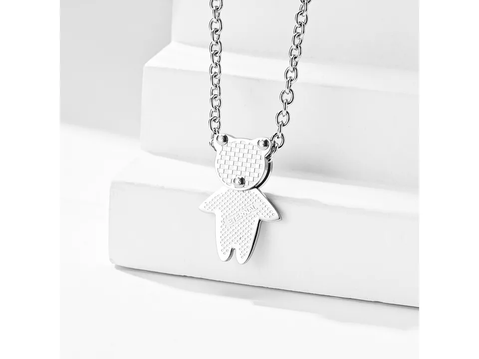 Silver bear pendant necklace on a white surface.