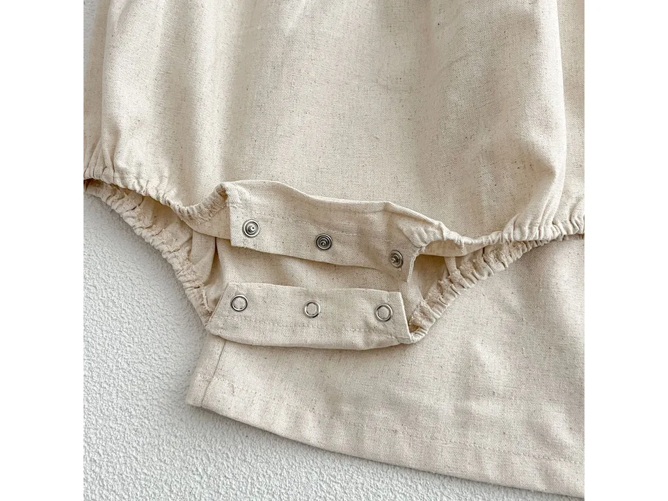 Close-up of the snap buttons on the bottom of the baby romper.