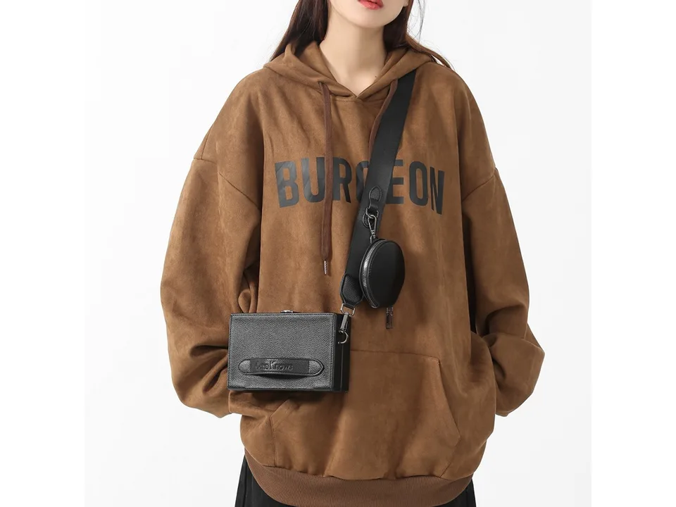 Close-up of a person wearing the black crossbody messenger bag with a detachable coin purse.
