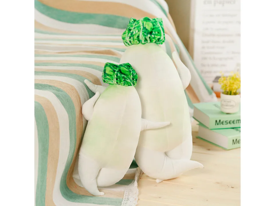 Two white radish plush toys standing on a table.
