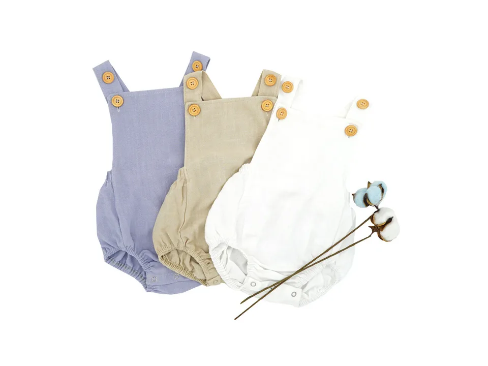 Three baby rompers in purple, beige, and white arranged together.