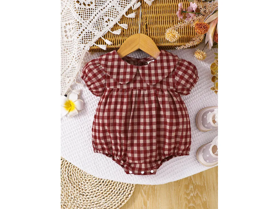 Full view of the red and white plaid baby romper on a hanger.