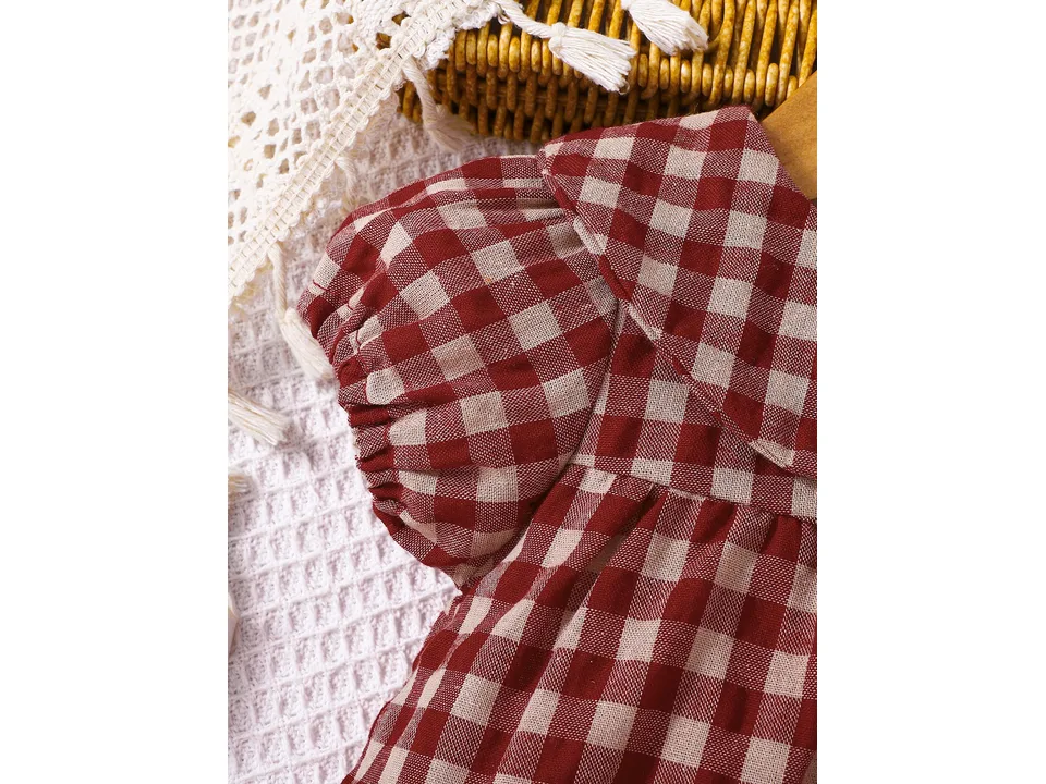 Close-up of the gathered sleeve on the plaid baby romper.