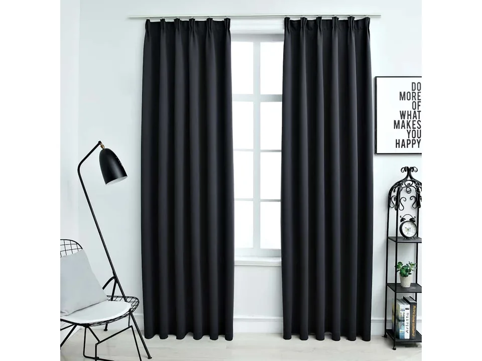 Black curtains hanging on a window in a modern living room.