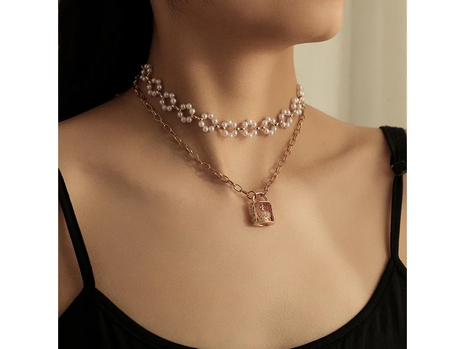 A person wearing the layered pearl and crown lock necklace.