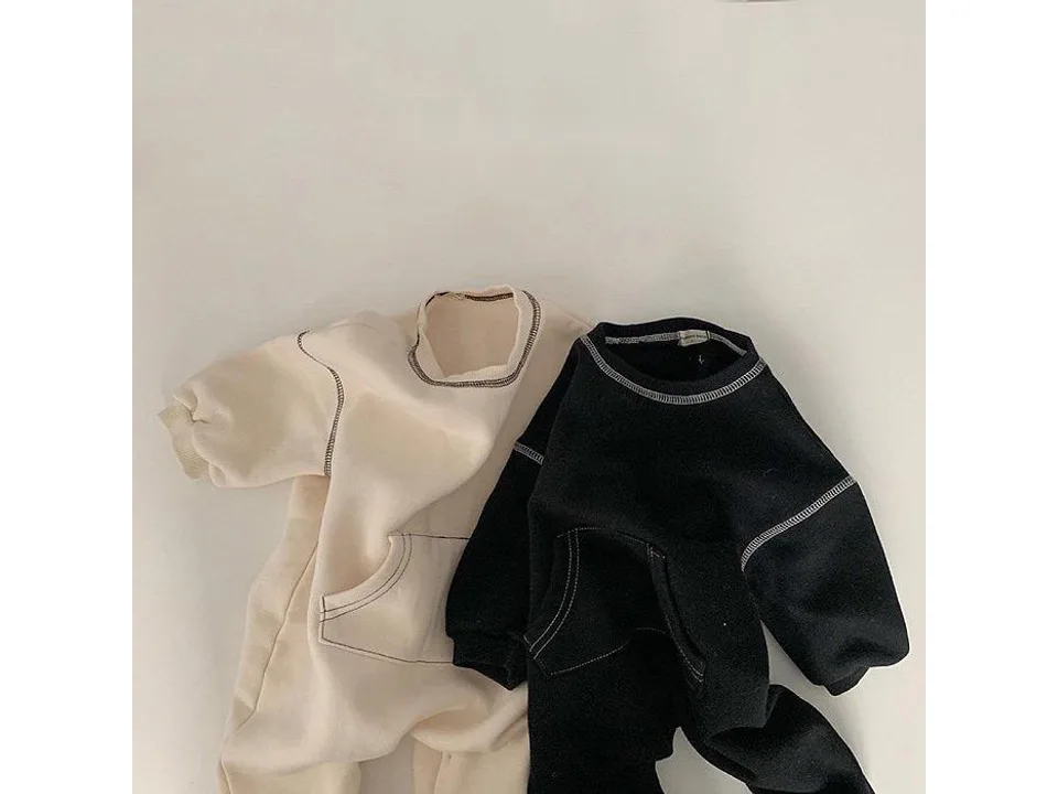 The black and white rompers laid out flat.