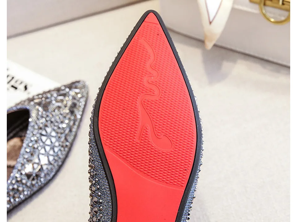 Close-up of the red sole of the rhinestone flat shoe.