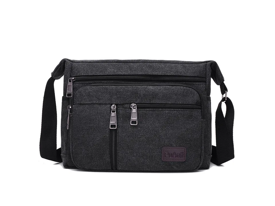 Black canvas crossbody messenger bag with multiple zippered pockets.