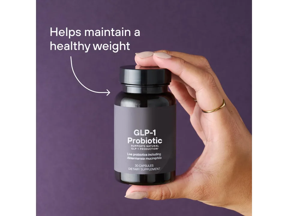 A hand holding the GLP-1 Probiotic supplement bottle.