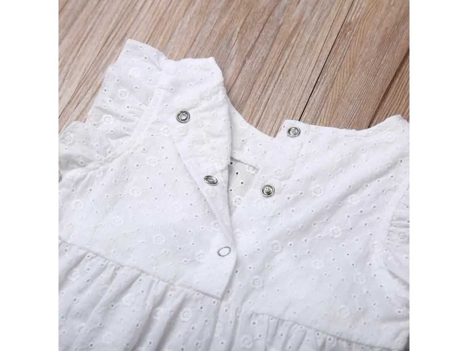 Close-up of the back of a white baby romper showing the snap button closure.