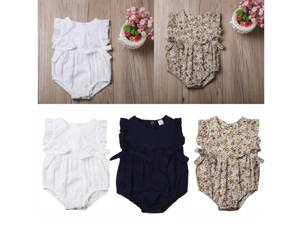 Two baby rompers, one white and one floral, displayed on a wooden background.