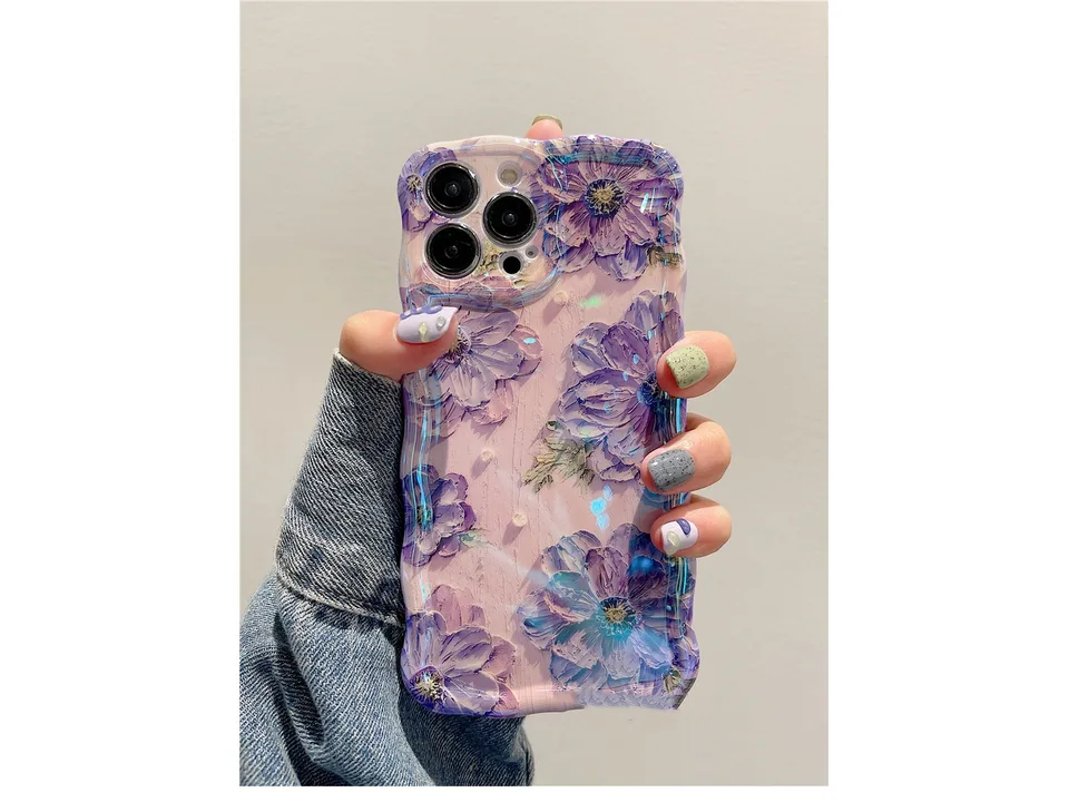 A hand holding a phone case with a purple floral oil painting design.