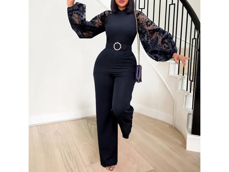 Model posing in the black jumpsuit with sheer floral sleeves