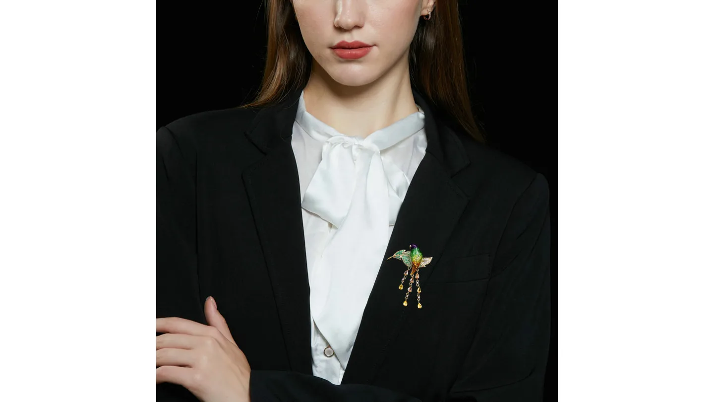 Woman wearing the parrot brooch on a black blazer.