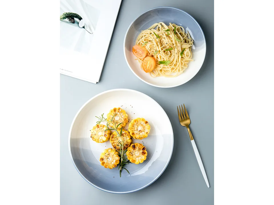 Two blue and white ceramic bowls, one with pasta and one with corn.