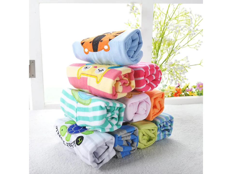 A stack of folded baby rompers with various colorful animal and striped patterns.