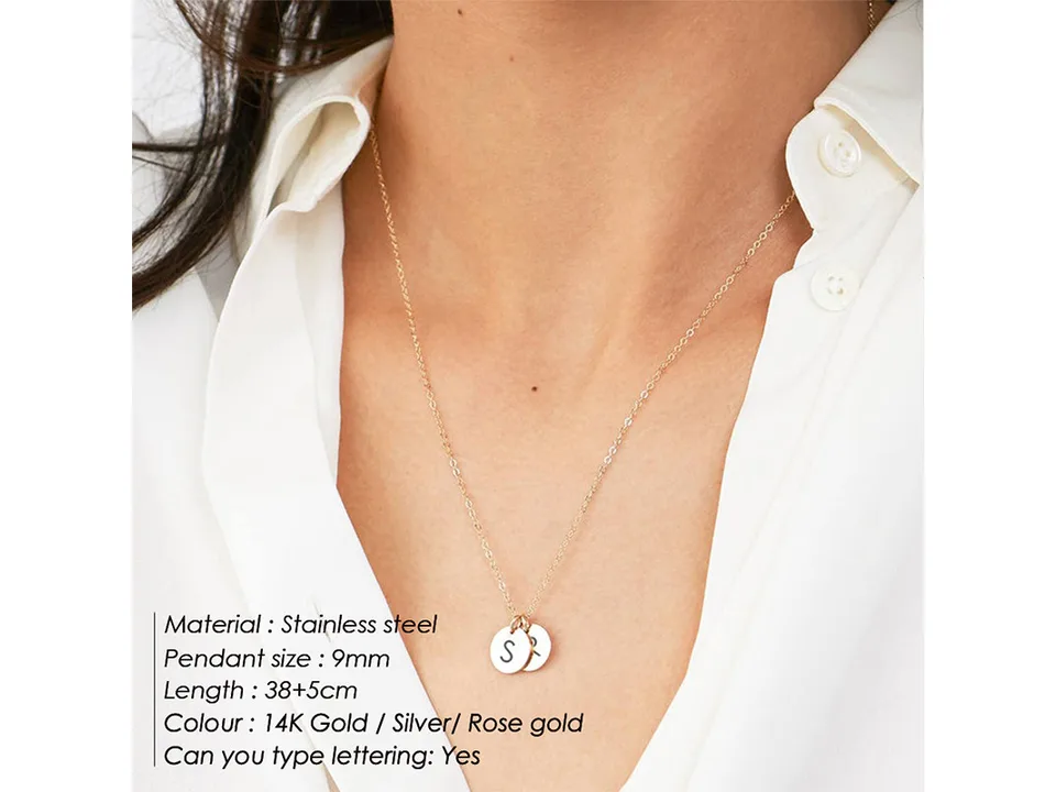 Close-up of a woman wearing a gold necklace with two small disc pendants.